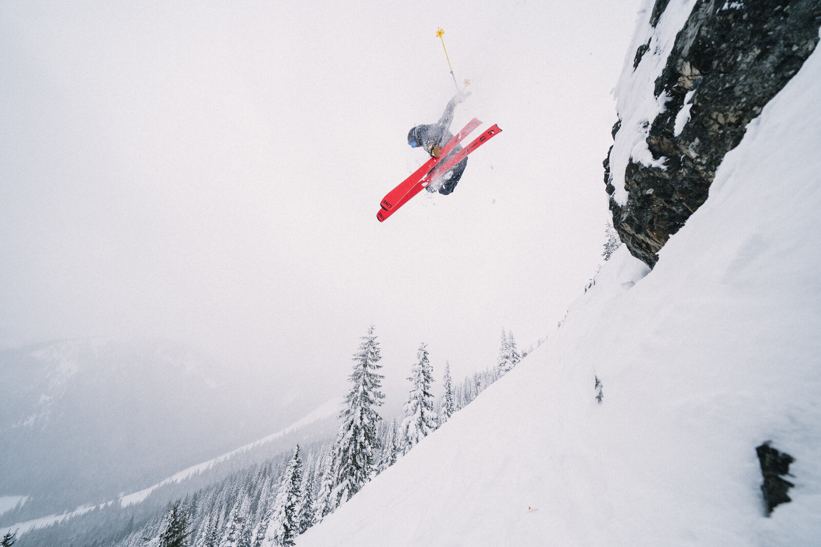 Connor throwing a backflip off a snowy cliff on red skis — years after his fourth ACL tear, with no ACL